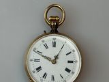 a gold pocket watch with roman numerals on the face