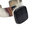 silver cuff bracelet with a black stone in the center