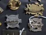 many different types of metal badges on a table