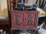 une armoire rouge surmontée d'une statuette de chien noir