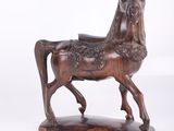 statue d'un cheval posée sur un socle en bois, avec un fond blanc