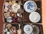 une boîte remplie d'objets divers, posée sur une surface rose