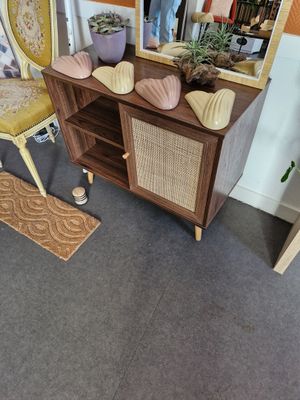 une commode avec un miroir et une chaise dans la pièce