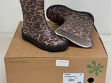 des bottes de pluie à imprimé léopard posées sur une boîte en carton, sur une surface blanche