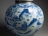 a blue and white vase with a lid on a table