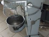 a mixer and a bowl on a stand in a kitchen