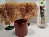 a brown vase with some flowers in it on a table