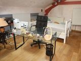 a desk with a chair and a bed in the room