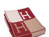the blanket is red and beige with a monogram on it