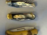 four different types of knives are lined up on a white surface