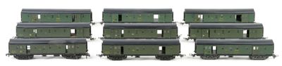 six green train cars sitting next to each other on a white surface