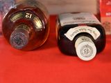 two bottles of liquor sitting on a table next to each other