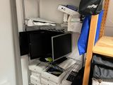 a room with a shelf, a chair, a microwave, and many other items