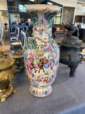 un grand vase posé sur une table, à côté d'autres objets