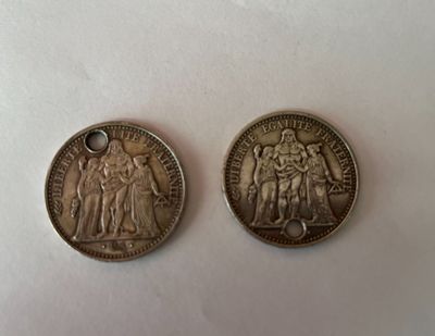 deux pièces d'argent posées l'une sur l'autre sur une surface blanche