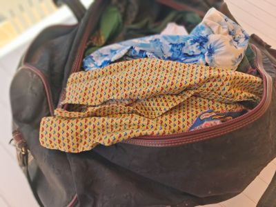 un sac en papier brun contenant une cravate et quelques vêtements