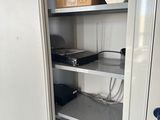 a white cupboard with a lot of electronics in it