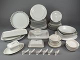 a lot of white plates and bowls on the table
