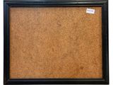 a black framed cork board with a tag on it