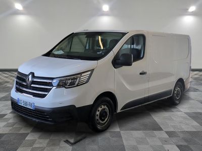 la camionnette blanche est garée sur le sol en damier d'un garage