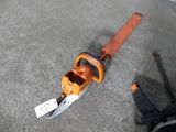 a chainsaw that is laying on the ground next to a person ' s feet
