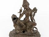 une statue en bronze représentant une femme assise sur un lion