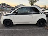 a small white car that is parked in a parking lot