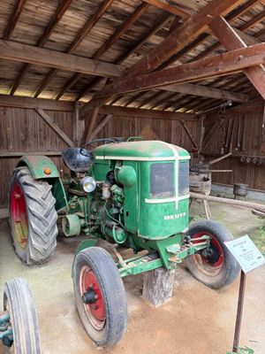 un tracteur vert garé à l'intérieur d'une grange