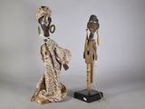 deux figurines en bois représentant des personnes en costume traditionnel, debout l'une à côté de l'autre