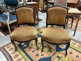 pair of antique chairs with upholstered back cushions on a rug
