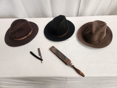 three hats on a table with a knife and a razor