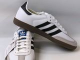 white and black adidas sneakers with brown soles on a white background