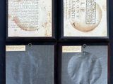 four pieces of old paper are hanging on a black wall