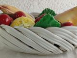 a white bowl filled with fruit and vegetables on a table