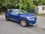 a blue car parked on the side of the road in front of a house