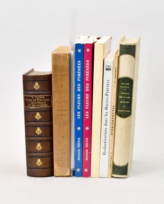 several books are stacked on top of each other on a white surface