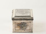 an antique silver box with a floral design on the lid