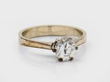a close up of a diamond ring on a white surface
