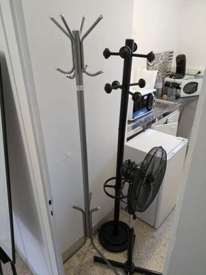 an image of a room with a fan and clothes rack
