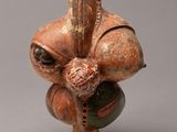 un gros plan d'une figurine en argile sur laquelle est perché un oiseau