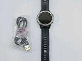 une montre connectée posée sur une table à côté d'un chargeur