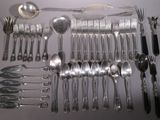 a lot of silverware on a table with spoons and forks