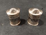 two silver salt and pepper shakers on a black surface