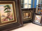 three framed pictures on a table next to a cage