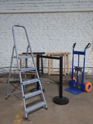 deux échelles, une table et un diable dans un garage