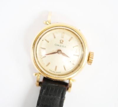 une photo d'une montre plaquée or montée sur un bracelet en cuir noir