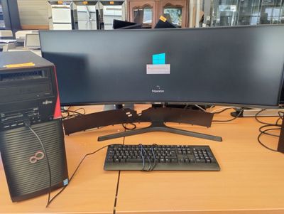 un ordinateur de bureau posé sur une table avec un clavier et un écran