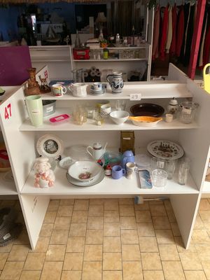 un placard blanc sur lequel sont posés de nombreux plats et tasses