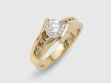 a yellow gold engagement ring with a round brilliant cut diamond