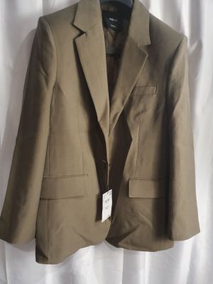 la veste est suspendue à un cintre accroché à un rideau blanc